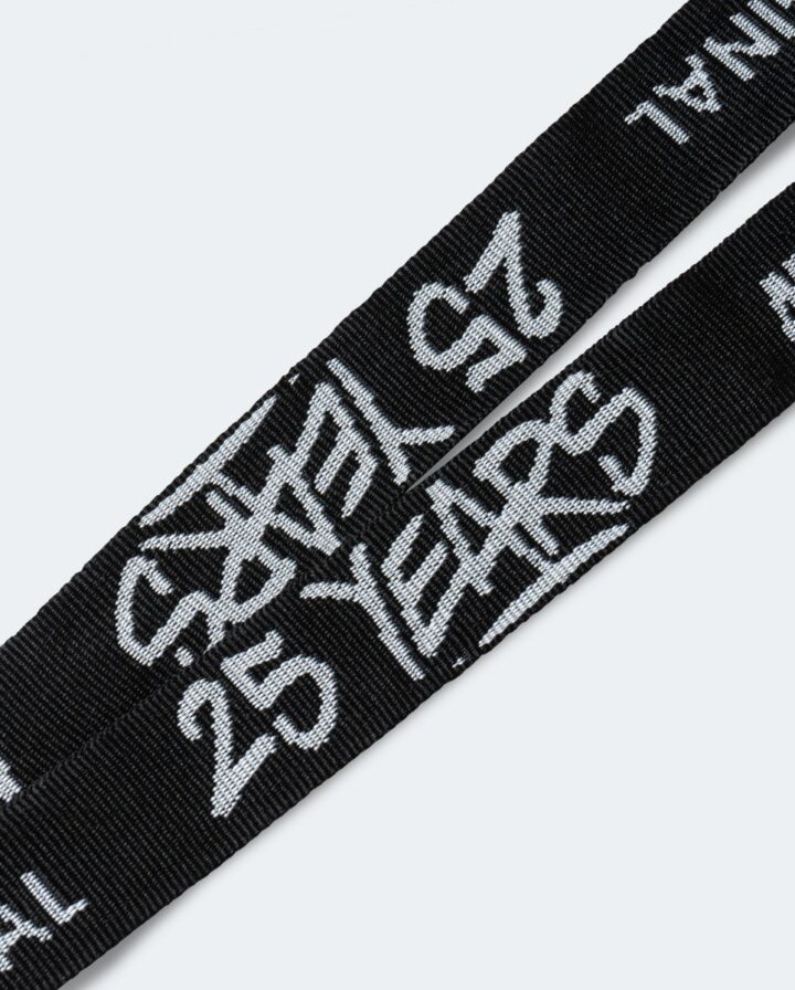 Detailfoto von weißer 25 Years Aufschrift auf einem schwarzen Schlüsselband der Marke Molotow