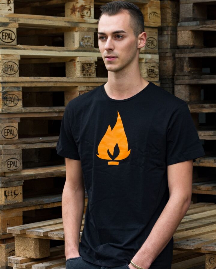 Foto von einem Mann mit schwarzem Shirt mit oranger Flamme als Print auf der Brust