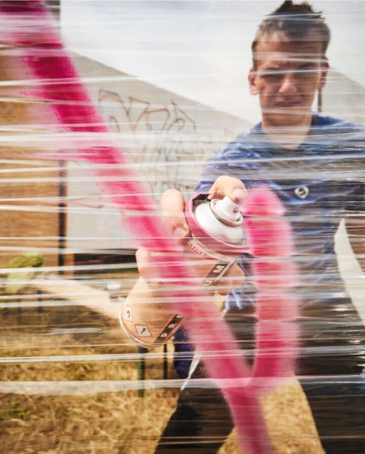 Anwendungsfoto einer transparenten Folie, die als Leinwand für Sprühfarbe in Pink genutzt wird